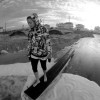 a young women balances on a post that was unearthed by the waves and now floats in the street