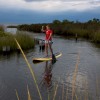 a girl standup paddles a girl standup paddles