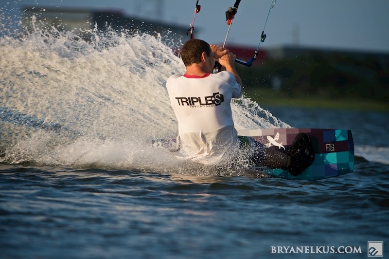 a kiteboarder edges in the water and prepares to do a trick