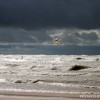 2 kiteboarders riding in waves with stormy skies on Lake Michigan