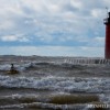 a kyaker paddles in front of the south haven pier in rough waters
