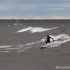 a surfer rides a wave on lake michigan