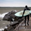 a lake michigan surfer walks out on the pier