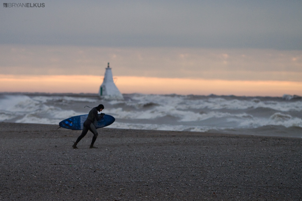 a surfer walks on the beach in Erieau Canada during a stormy day on Lake Erie