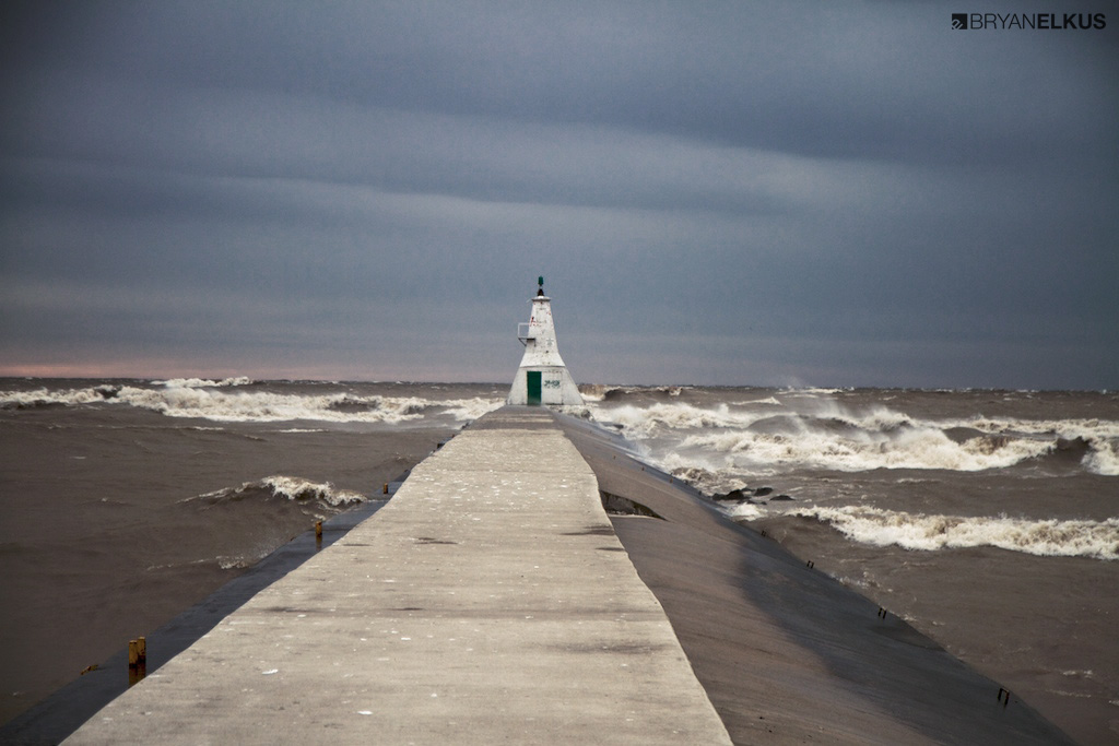 a view of waves crashing next to the Erieau lighthouse