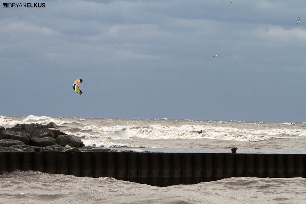 a kiteboarder rides waves on lake eire